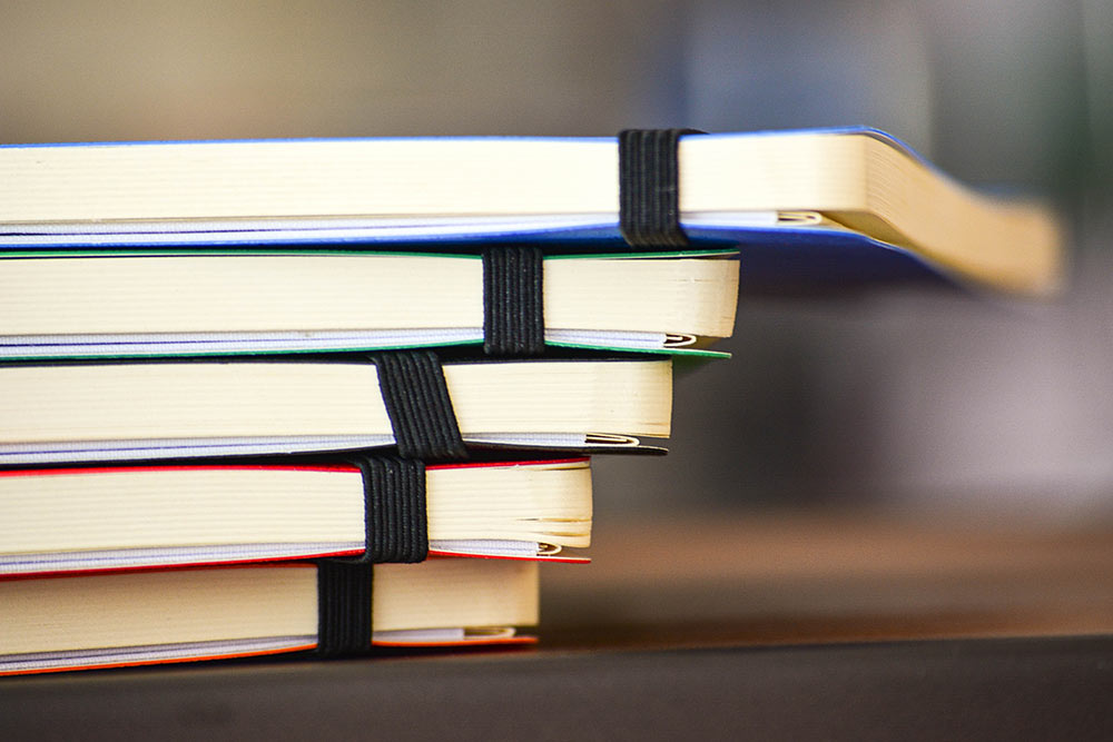 page edges from stack of notebooks with elastic bands